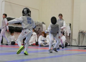 Young foil fencers try to find the right fencing strategy in the bout